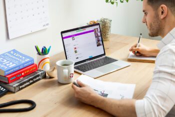 Person sitzt vor dem Laptop und arbeitet mit der Mimeo Digital Plattform