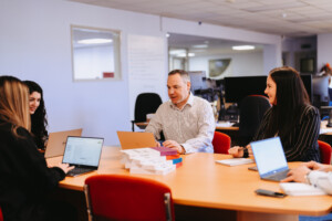 Unternehmensteam sitzt gemeinsam an einen Schreibtisch