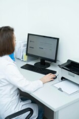 Clinical trial documentation auf einem Schreibtisch an einem computer